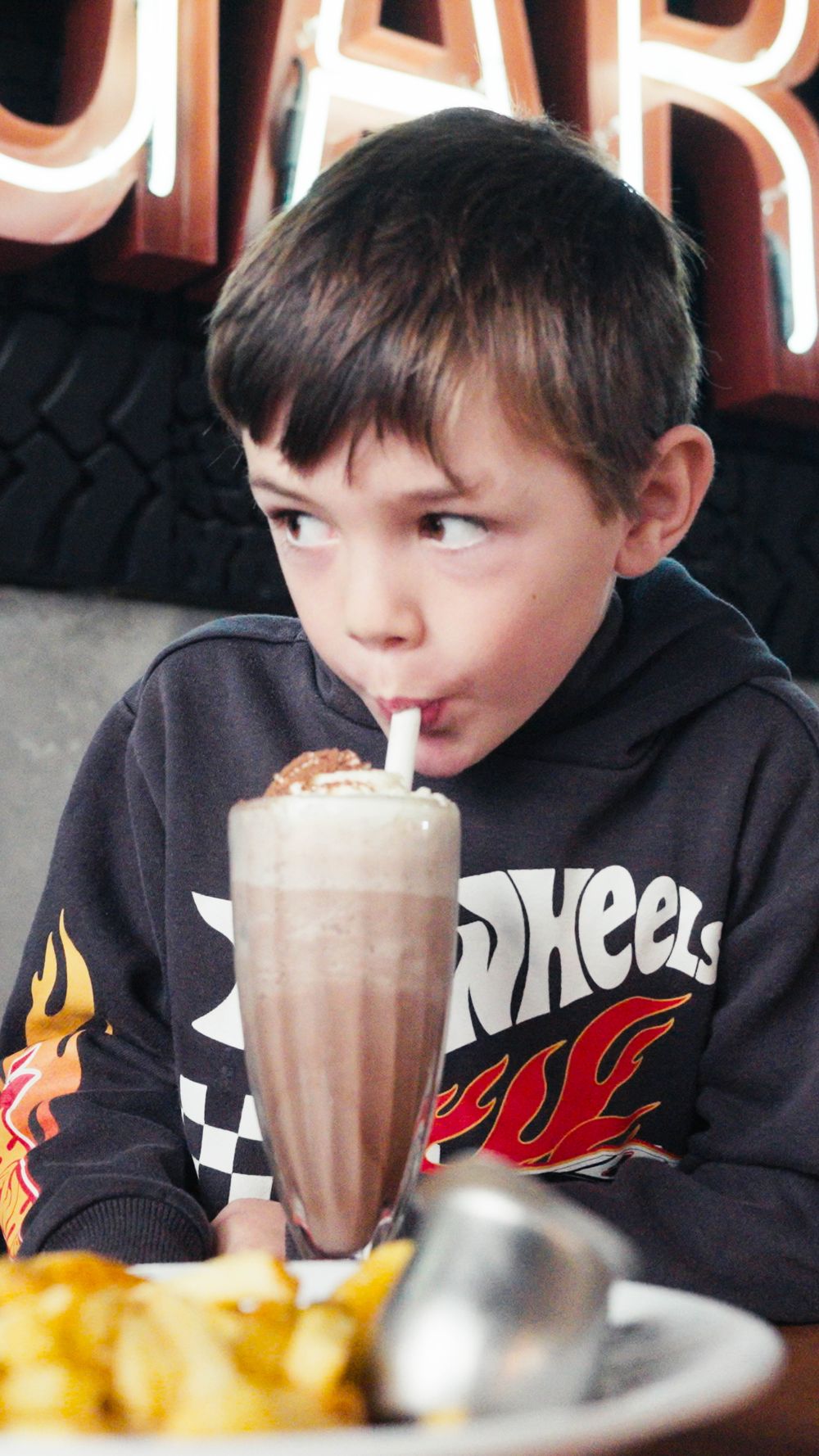 A kid enjoying a milkshake at Five Mile