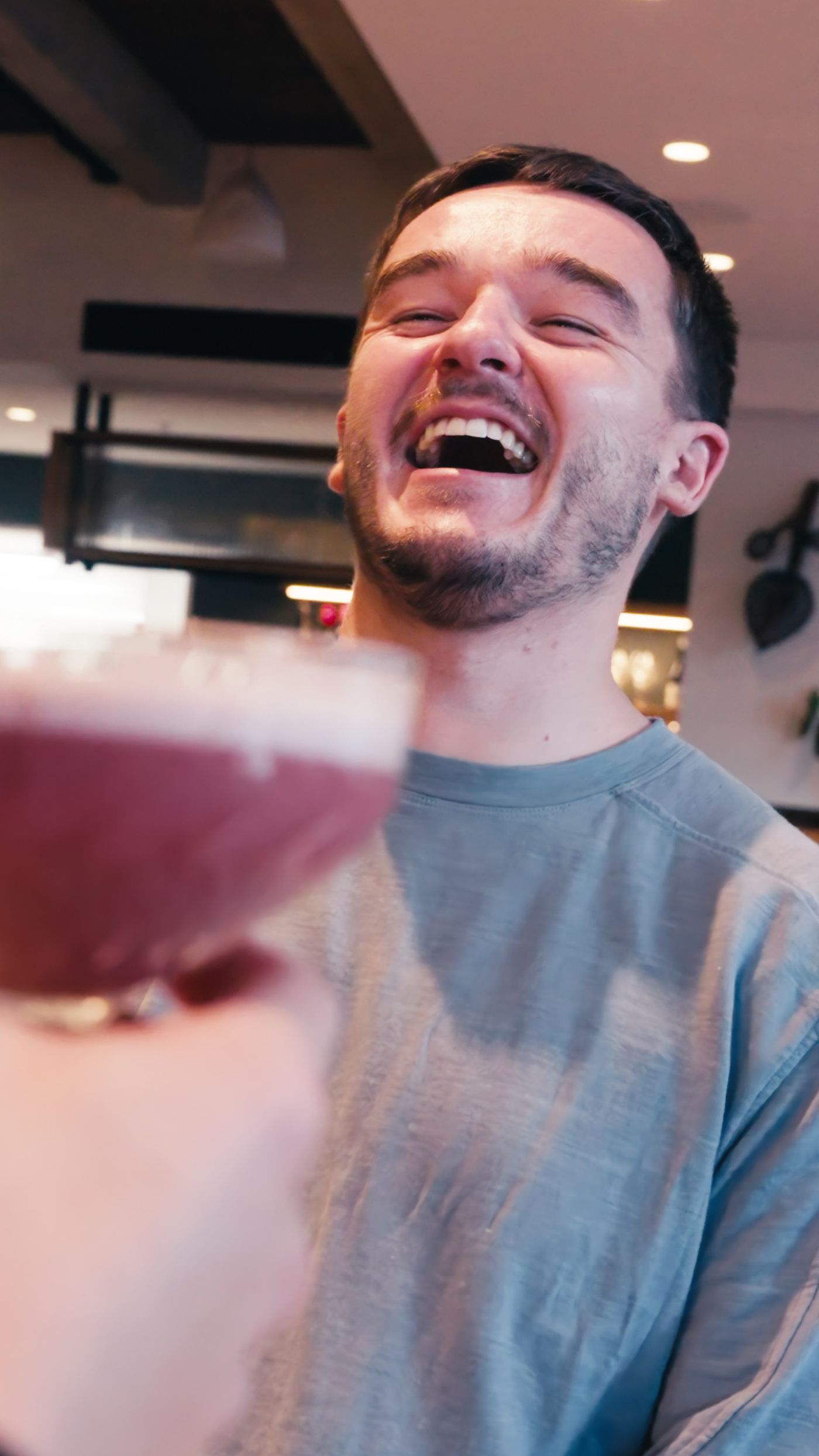 Friends laughing over drinks at a Five Mile restaurant